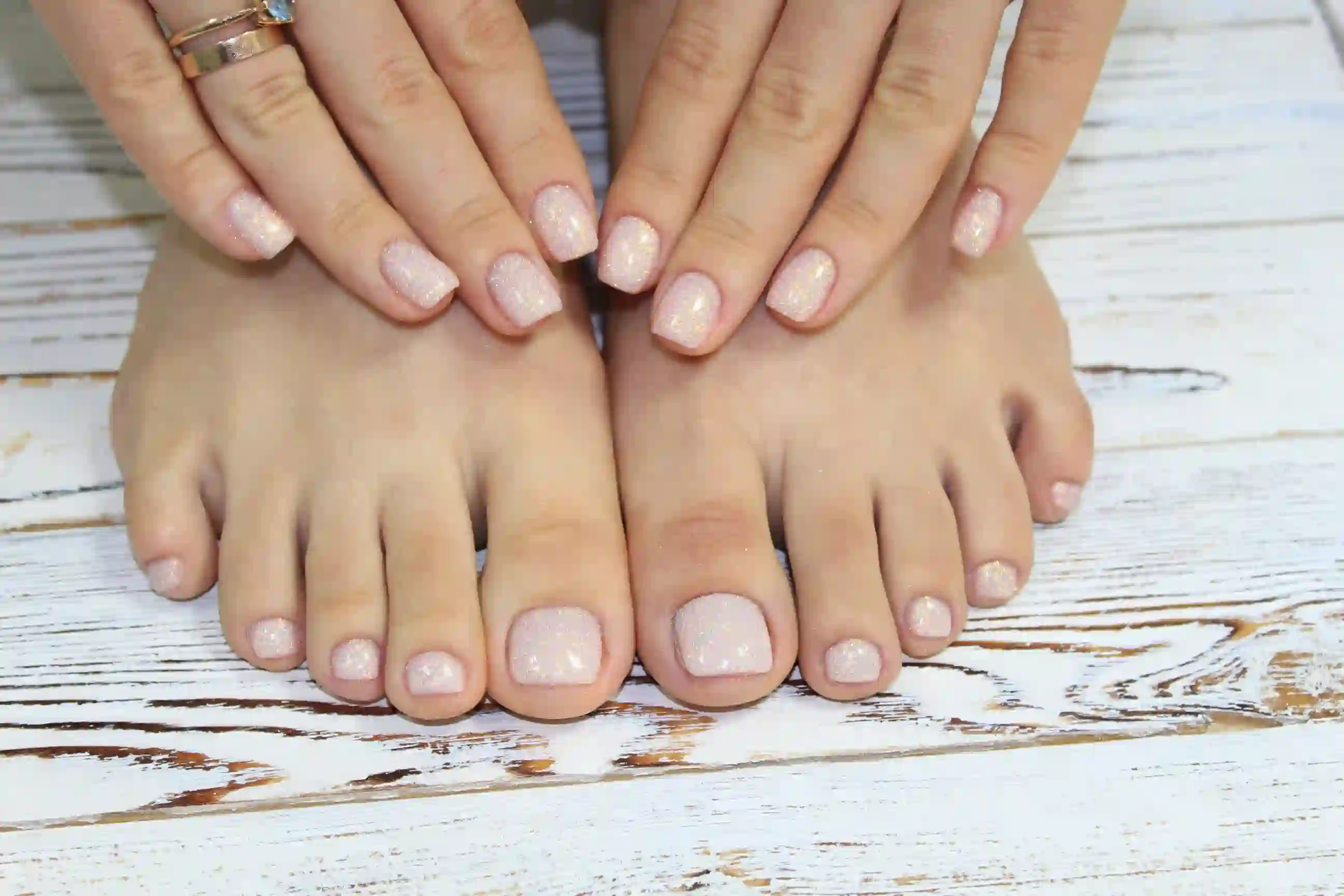 Close-up of a pale pink glitter pedicure finished during an Opalya luxury mobile pedicure appointment at a clientโs home.