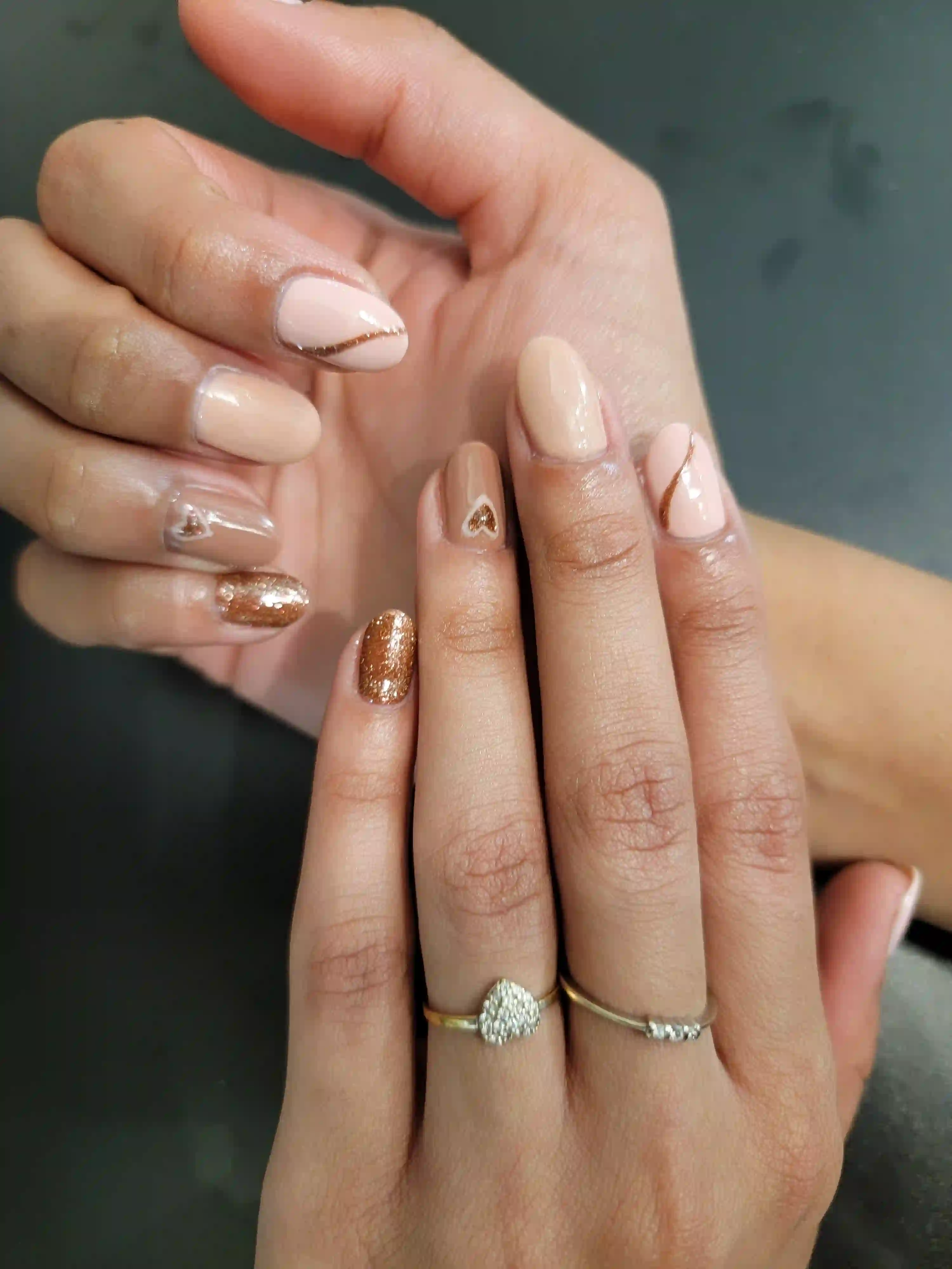 Neutral nude manicure with gold glitter accents and delicate nail art on almond shaped nails, luxury mobile nail service by Opalya in Toronto