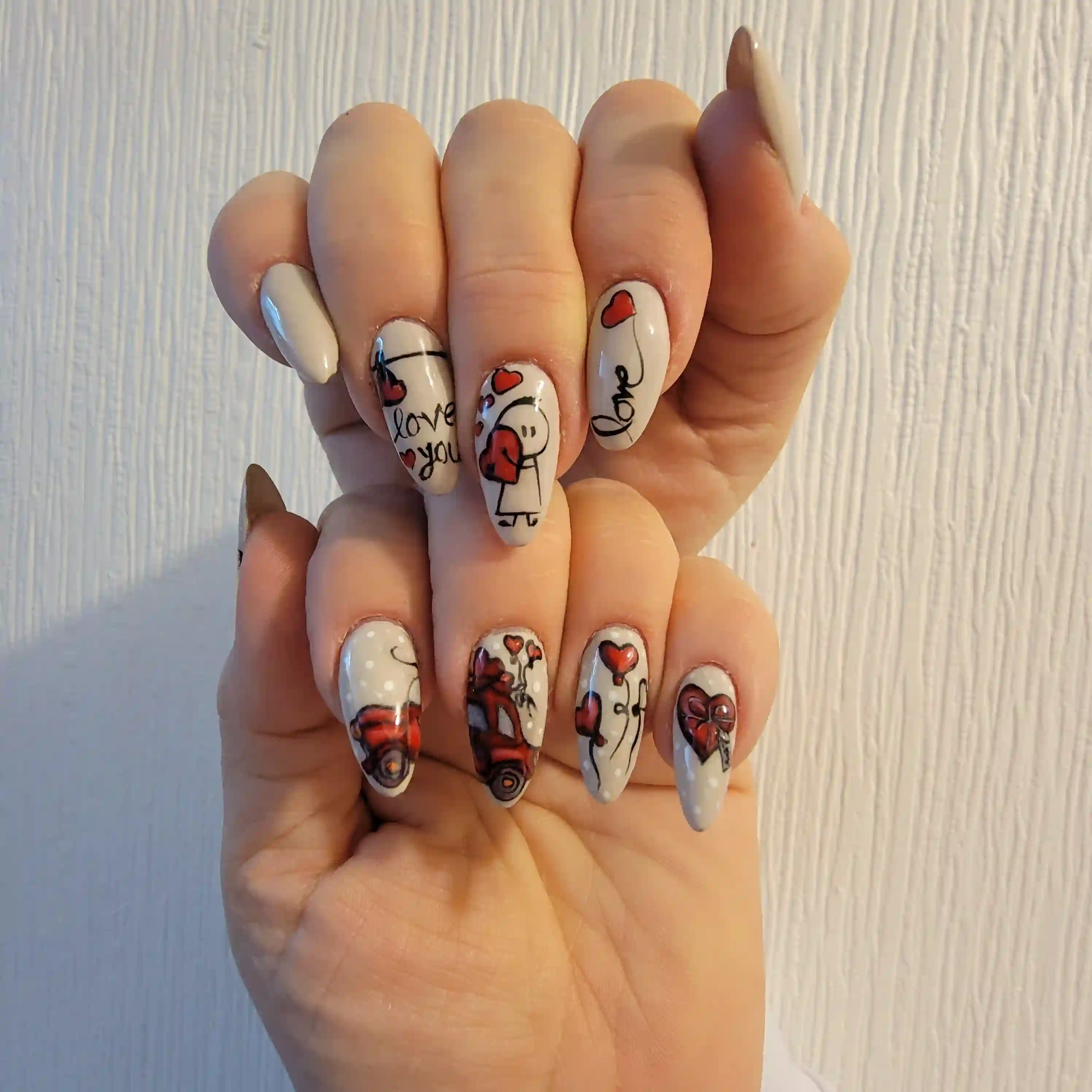 White almond nails with hand painted love themed nail art and red heart illustrations, romantic gel manicure by Opalya mobile nail service