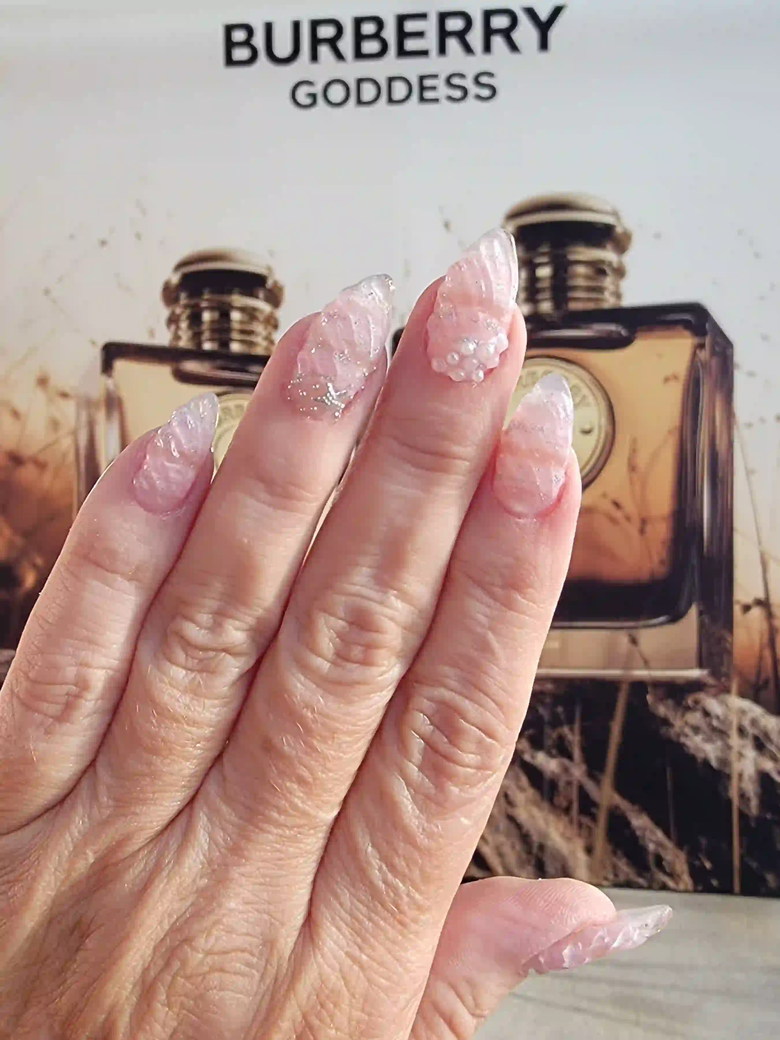 Soft pink textured stiletto nails with pearl accents and crystal details, elegant luxury manicure by Opalya mobile nail service