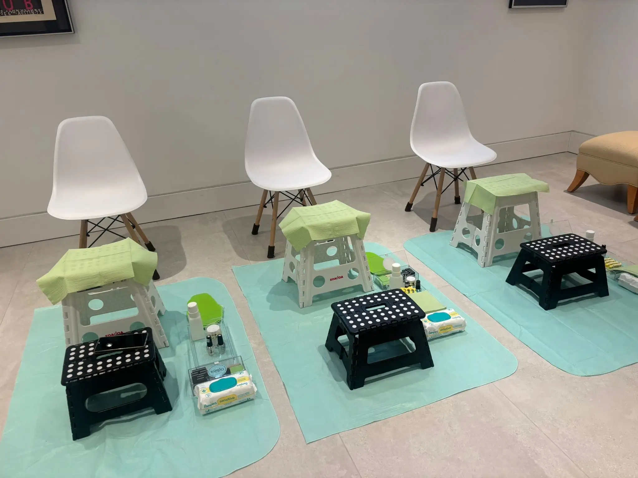 Clean and organized at-home pedicure stations with stools, tools, and protective mats prepared for guests.