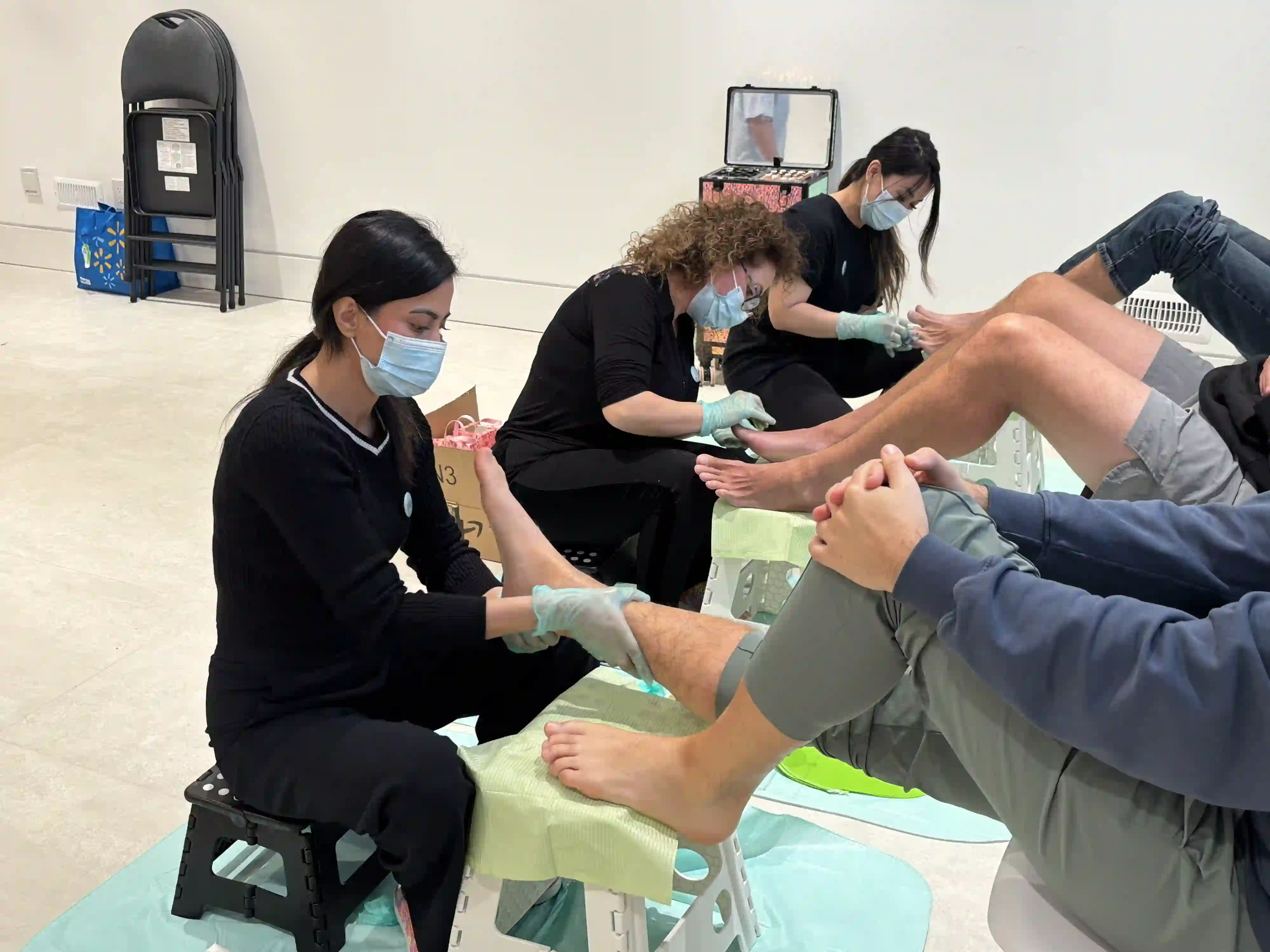 Mobile spa technicians performing pedicures for guests during an at-home birthday spa experience.