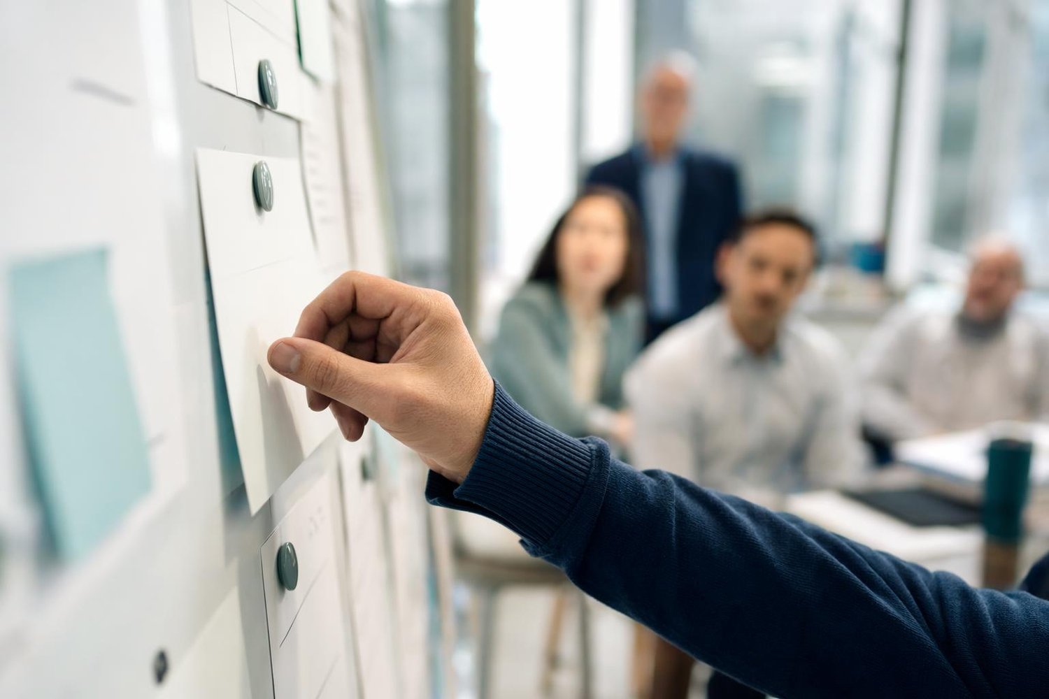 Groupe de cinq professionnels en atelier d'identification de cas d'usage en intelligence artificielle devant un tableau blanc dans un bureau québécois moderne.