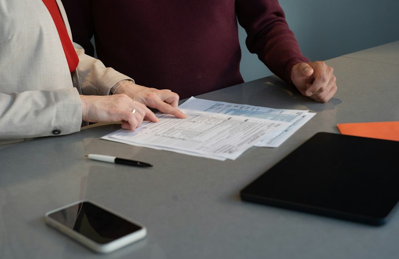 Deux professionnels examinent des documents de travail pendant une réunion au bureau.