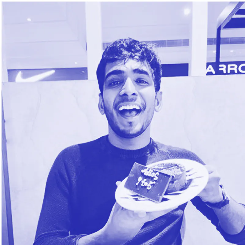 Smiling young man holding a plate with a dessert and a chocolate piece