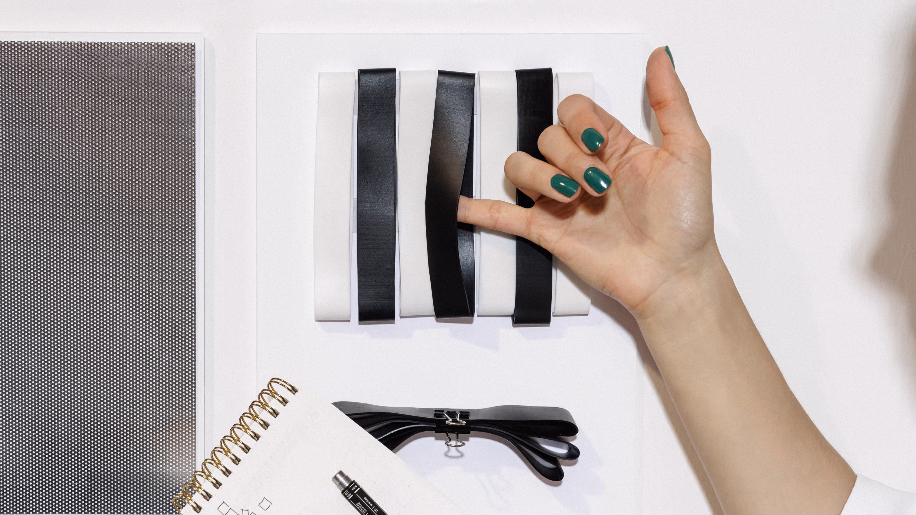 Materialwand mit schwarzen und weißen Silikonbändern zur haptischen Markenentwicklung bei Brands New Future.