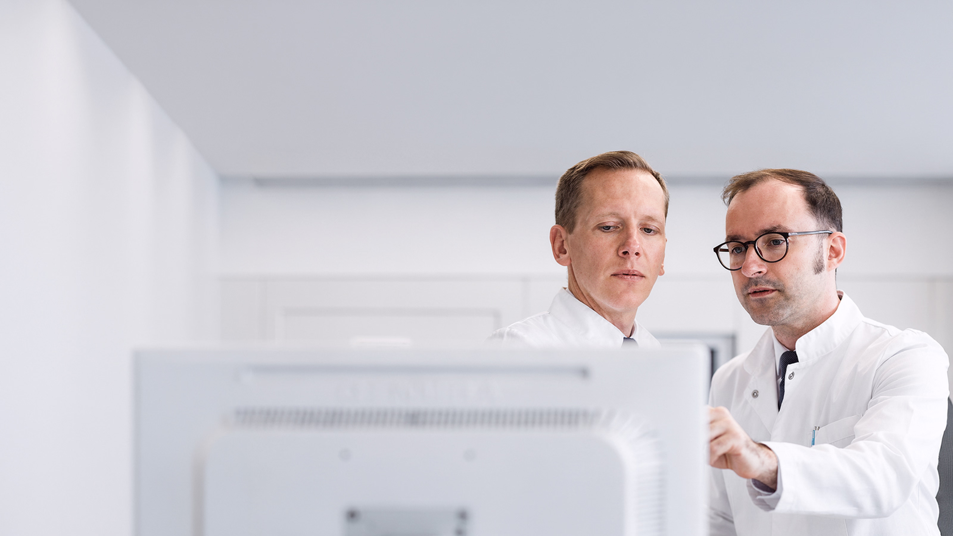 Ärzte analysieren gemeinsam klinische Daten am Bildschirm in einem MedTech Kontext