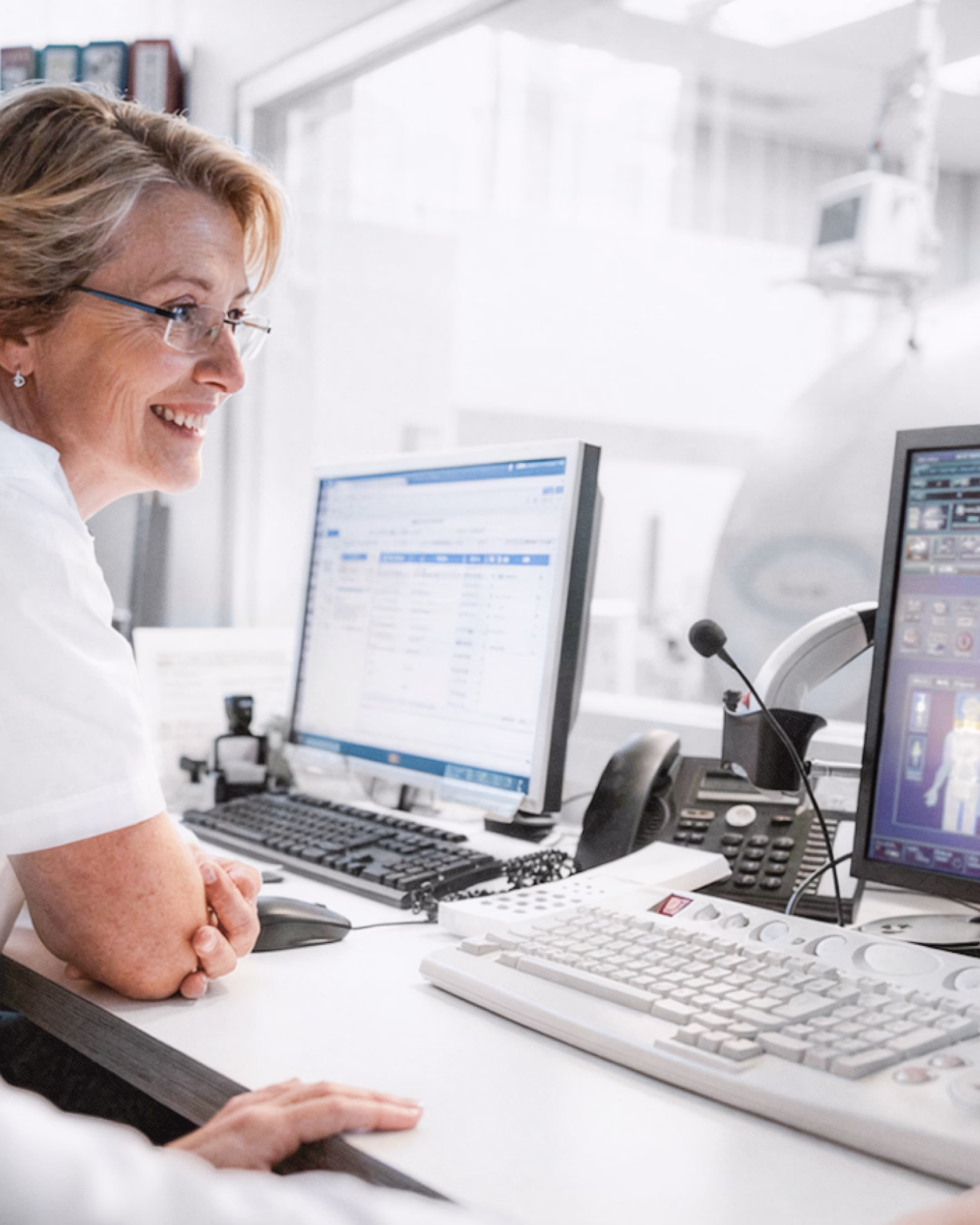 Ärztin analysiert medizinische Software am Monitor – klinischer Workflow und MedTech Interface im Einsatz zur Unterstützung der Adoption im Krankenhaus.