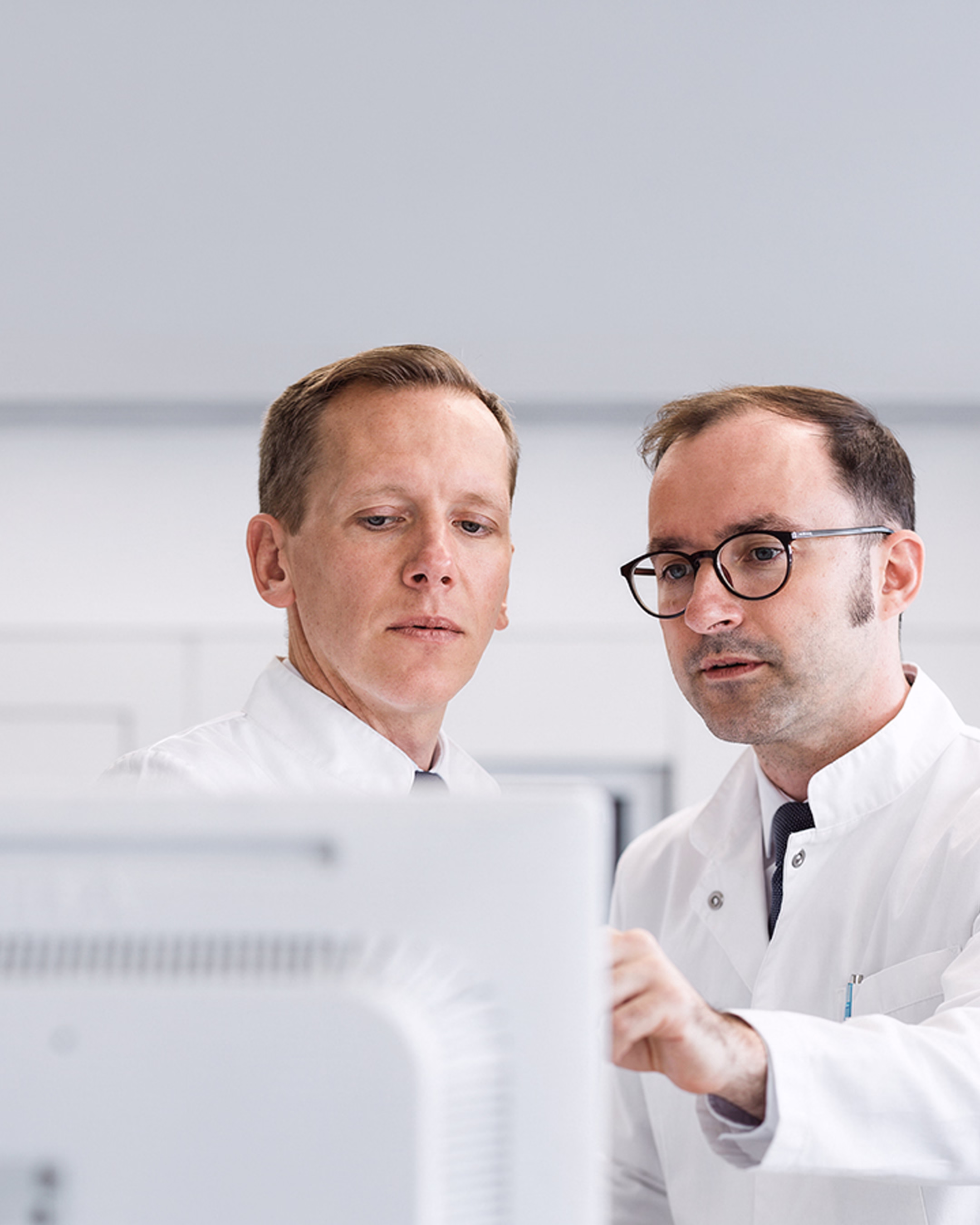 Ärzte analysieren gemeinsam klinische Daten am Bildschirm in einem MedTech Kontext