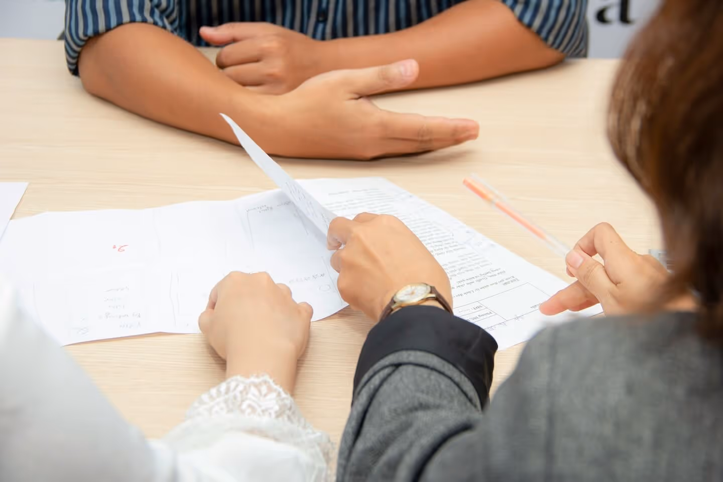 Two people discussing documents across a table