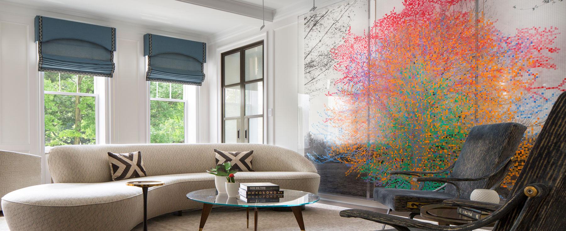 Modern living room with curved sofa and colorful wall art.