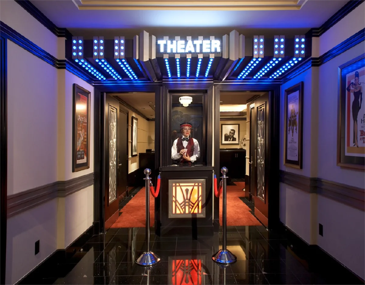 Home theater entrance with illuminated marquee and ticket booth.
