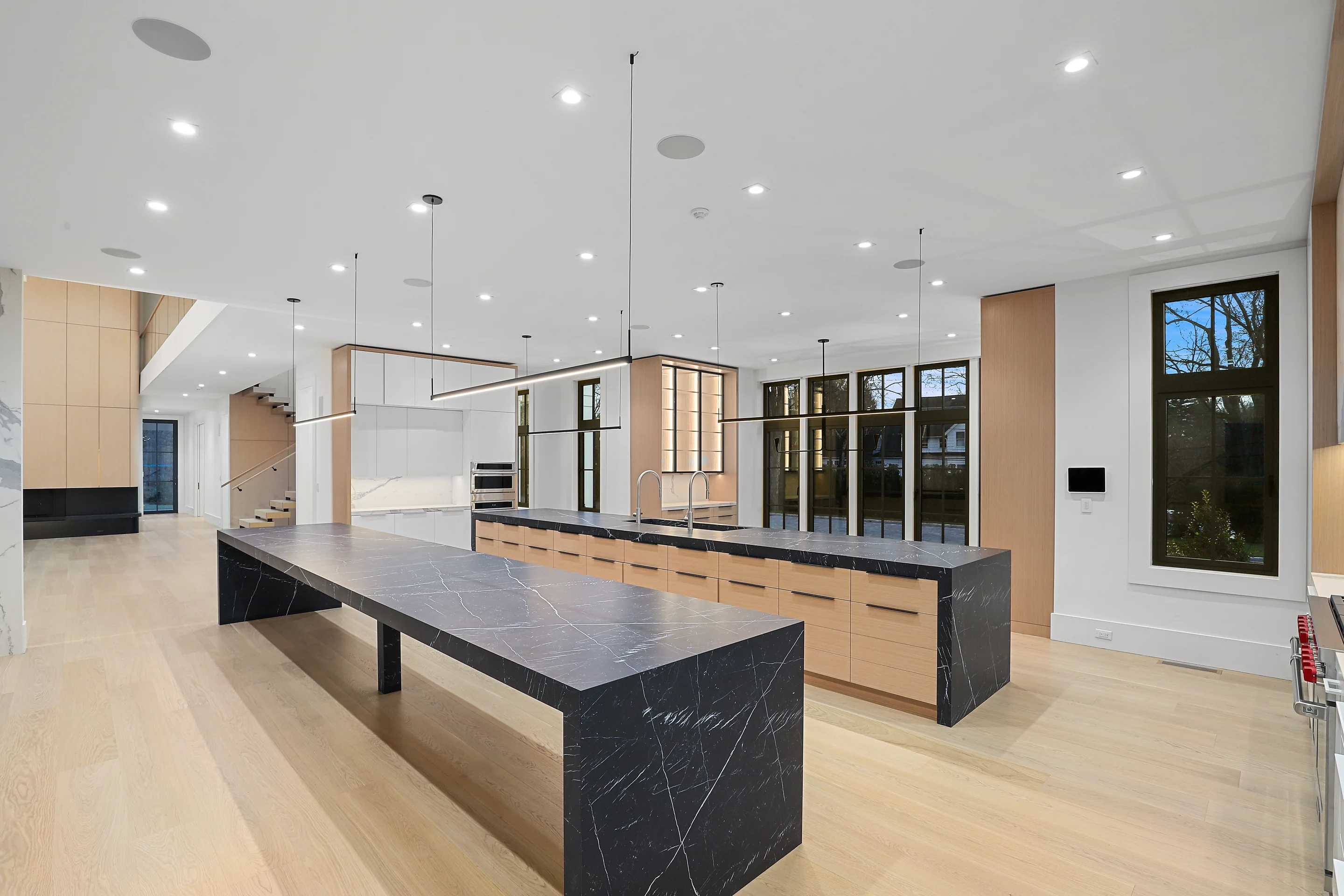 Contemporary kitchen with large marble island and recessed ceiling lights.
