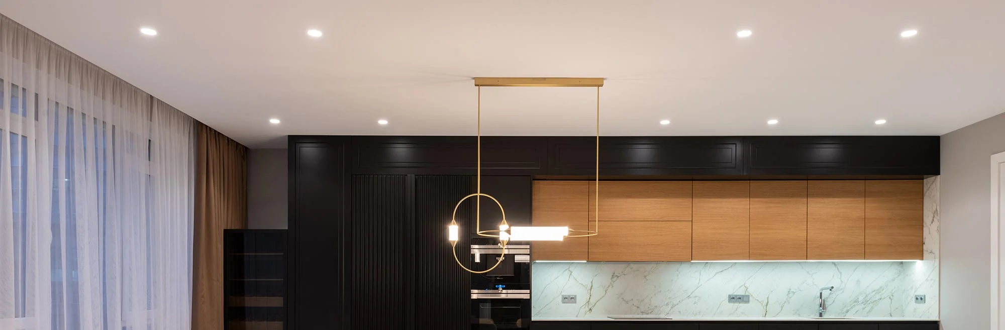 Modern kitchen with wood cabinets and pendant light.