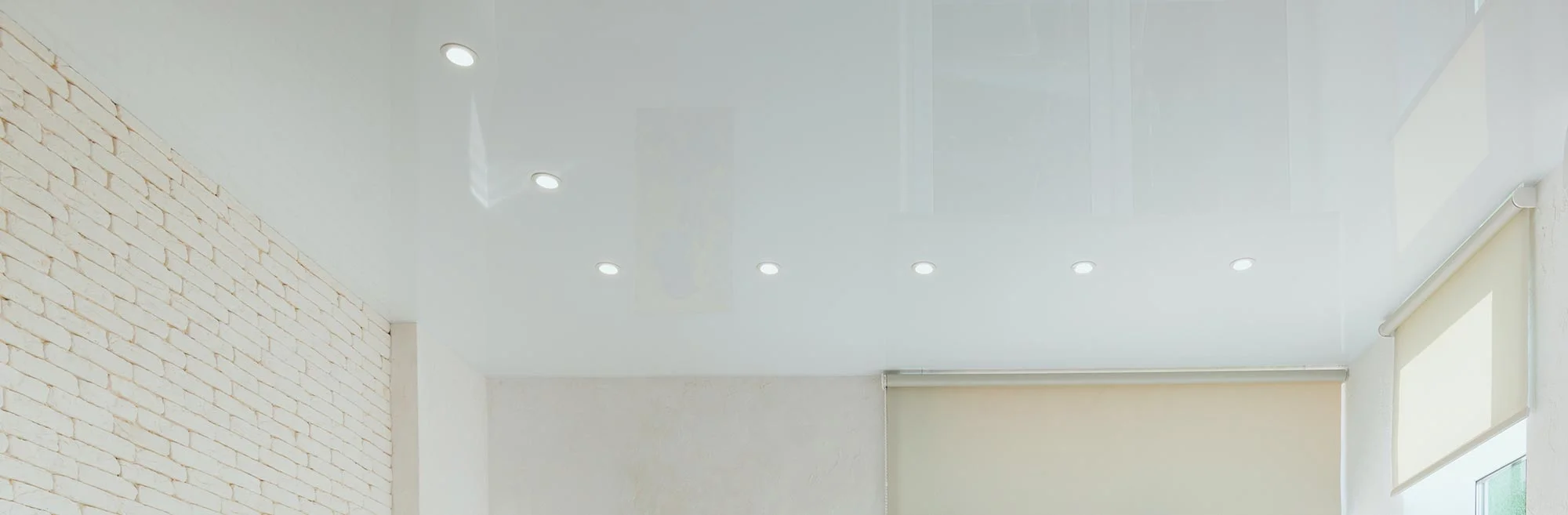 Ceiling with recessed lights and brick wall.