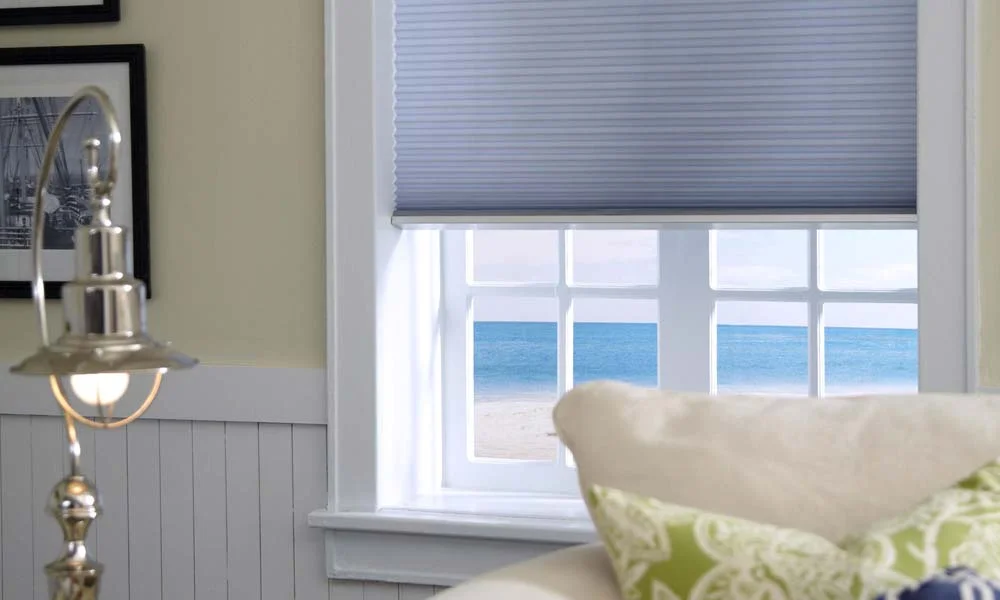 Window with shade and ocean view.