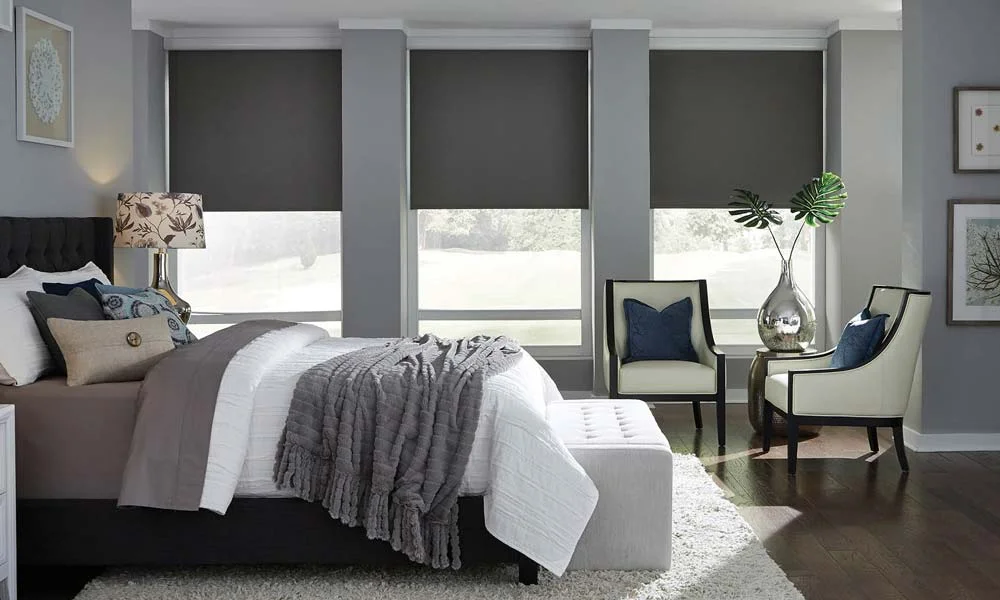 Modern bedroom with large windows and gray shades.