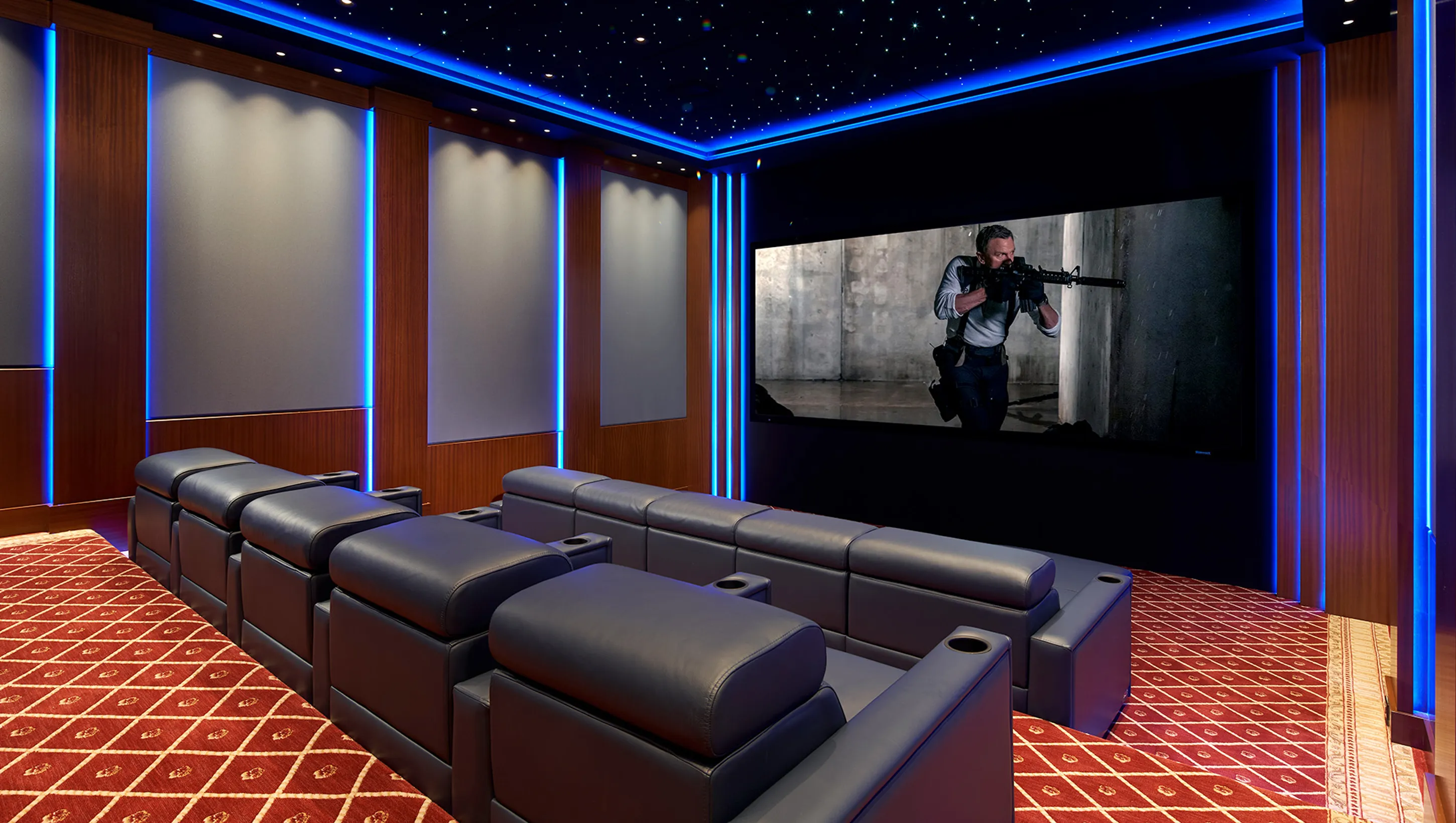 Home theater with large screen and blue accent lighting.