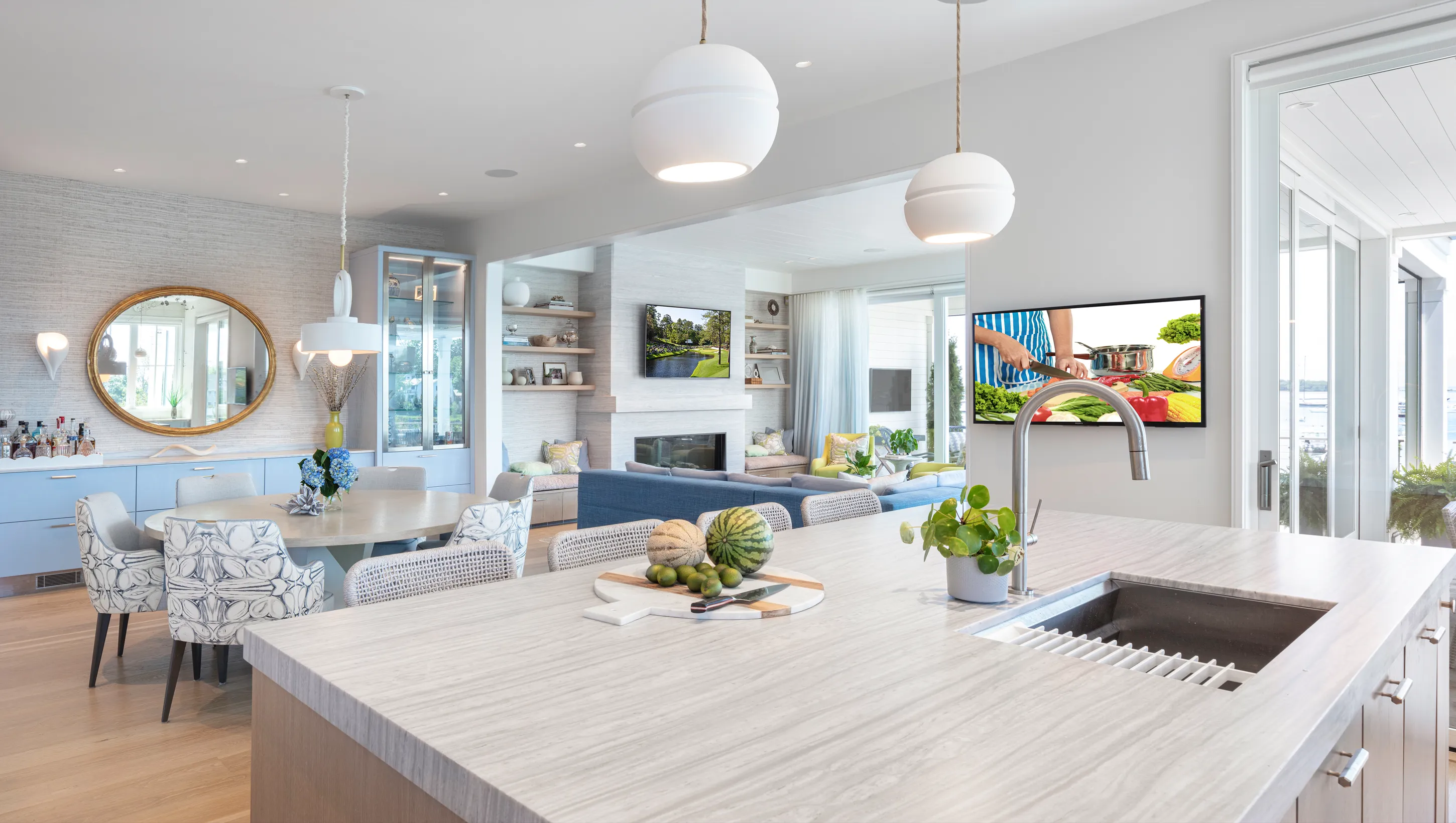 Bright open kitchen and living room with island and TV.