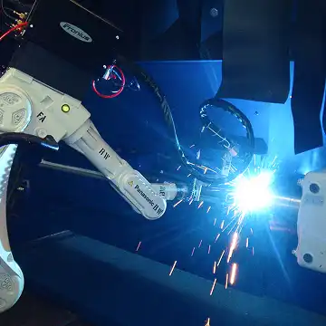 3D-Nahtschweißmaschinen mit hellen Funken in dunkler Fabrikumgebung.