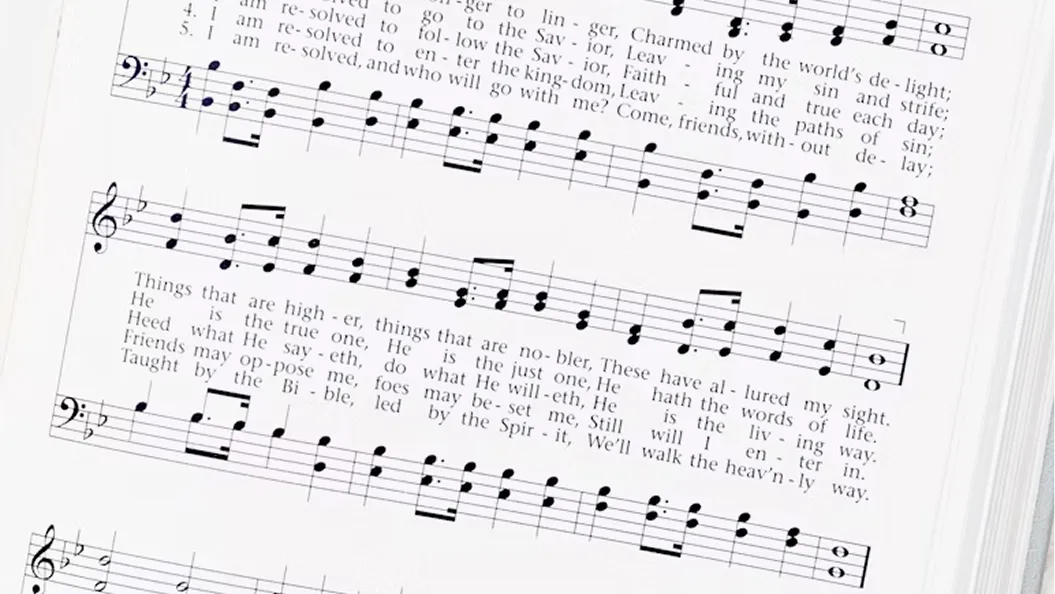 Sheet music with musical notes and lyrics of a hymn, showing treble and bass clefs on a white page.