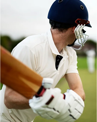 Cricket player batting and ready for pitch.