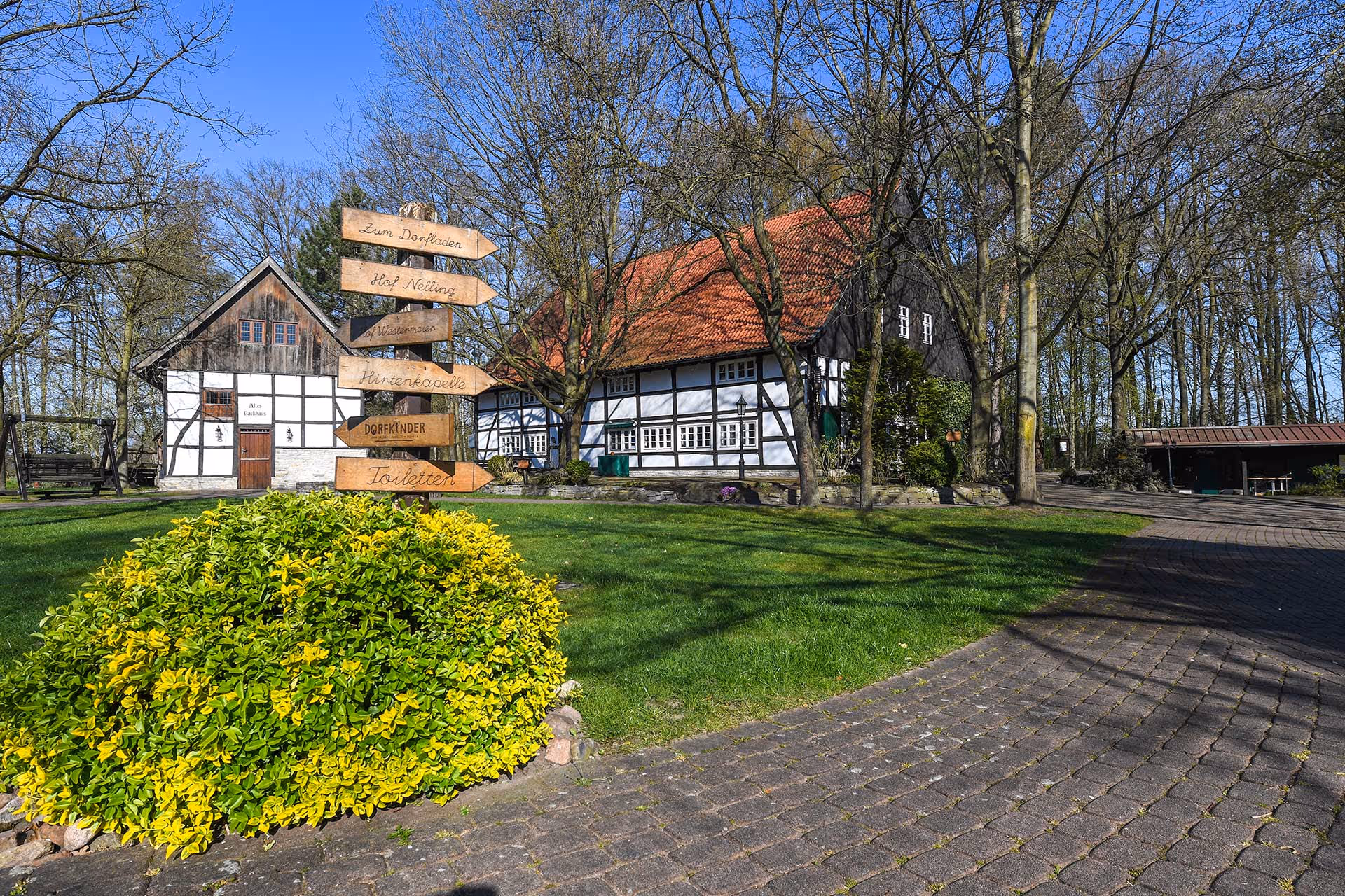 Außenbereich fotografiert mit einem Wegweiser in dem Vordergrund.