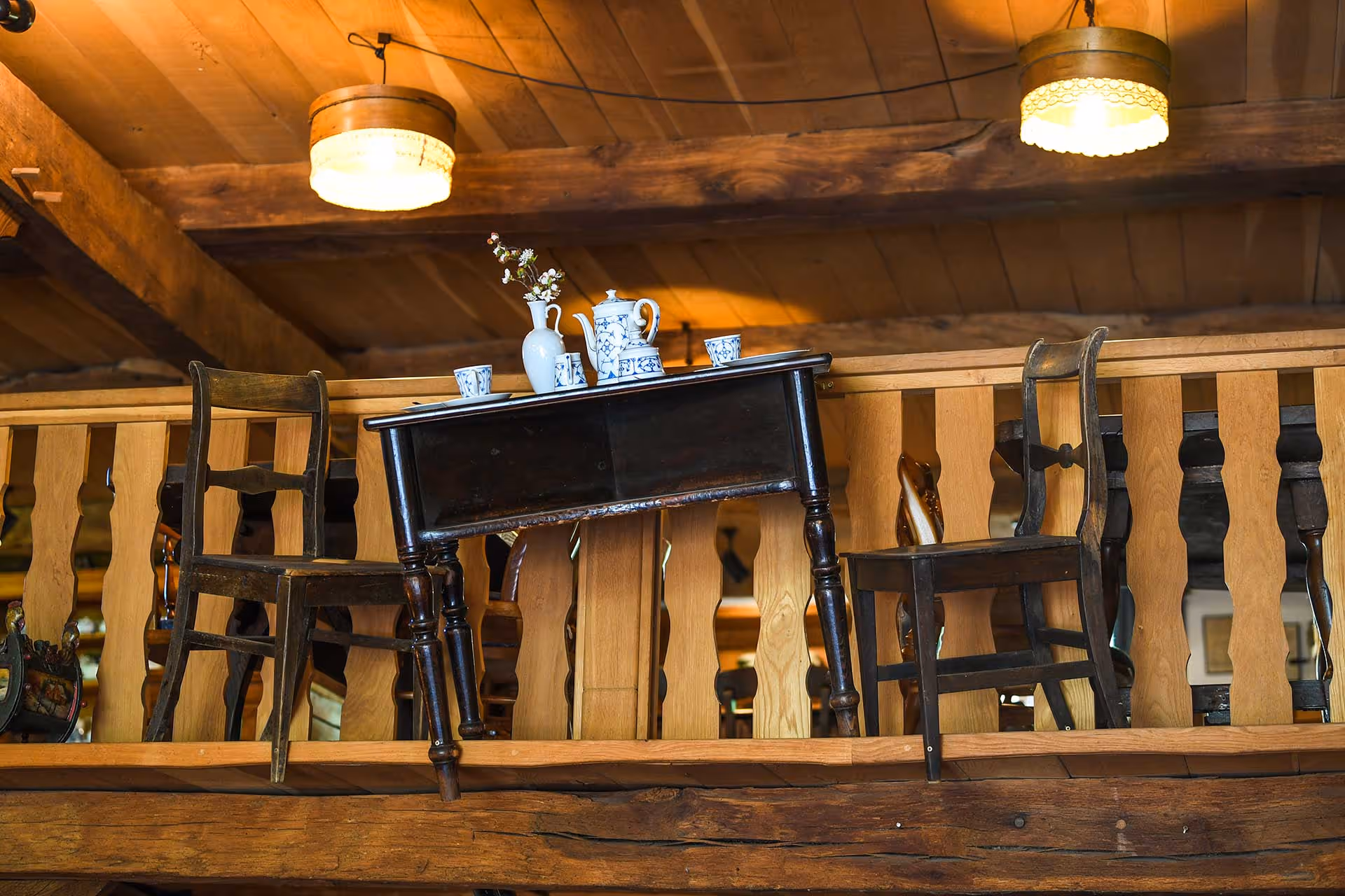 Zwei Stühle und ein Tisch ans Geländer befestigt.