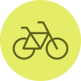 Ein einfaches Symbol eines Fahrrads in dunklem Braun auf grünlichem Kreis-Hintergrund.