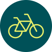 Gelbes Fahrradsymbol vor dunkelgrünem rundem Hintergrund.