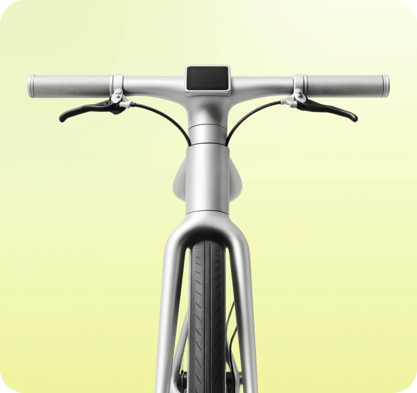 Vordere Ansicht eines modernen, grauen Fahrrads mit digitalem Display am Lenker vor gelbem Hintergrund.