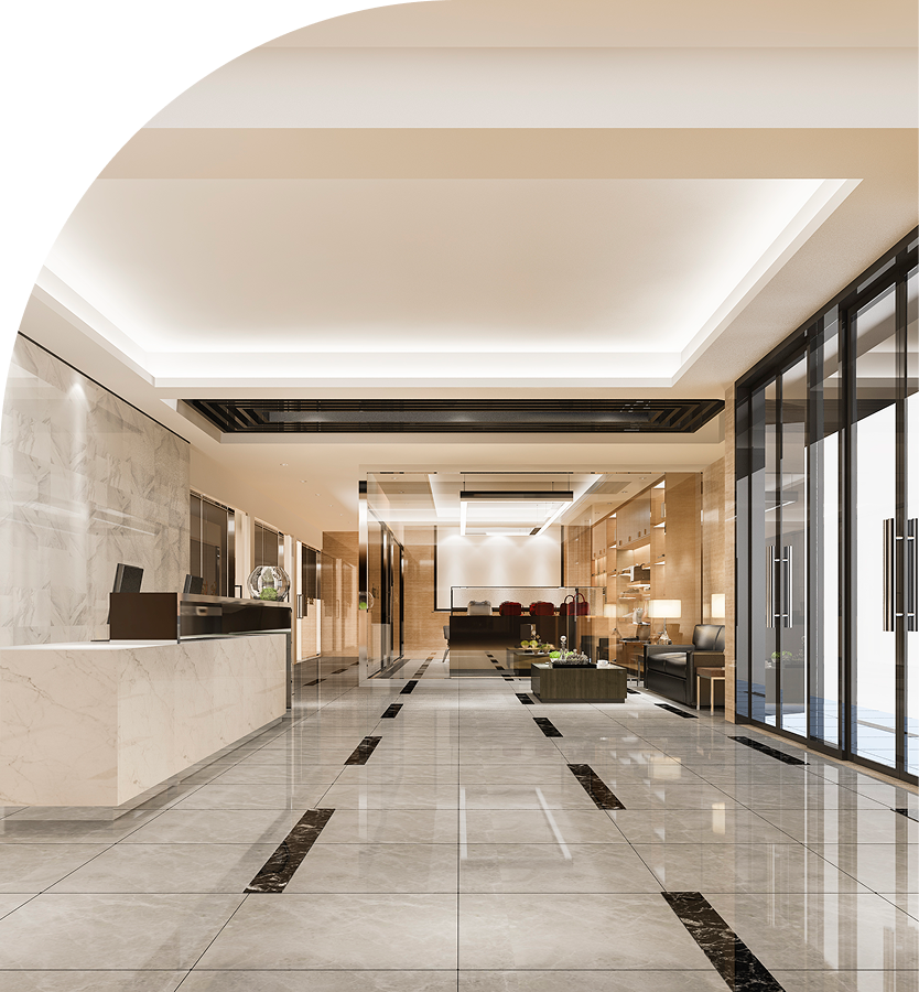 Modern hotel lobby with marble flooring, reception desk on the left, and a seating area with black chairs and coffee tables in the background.