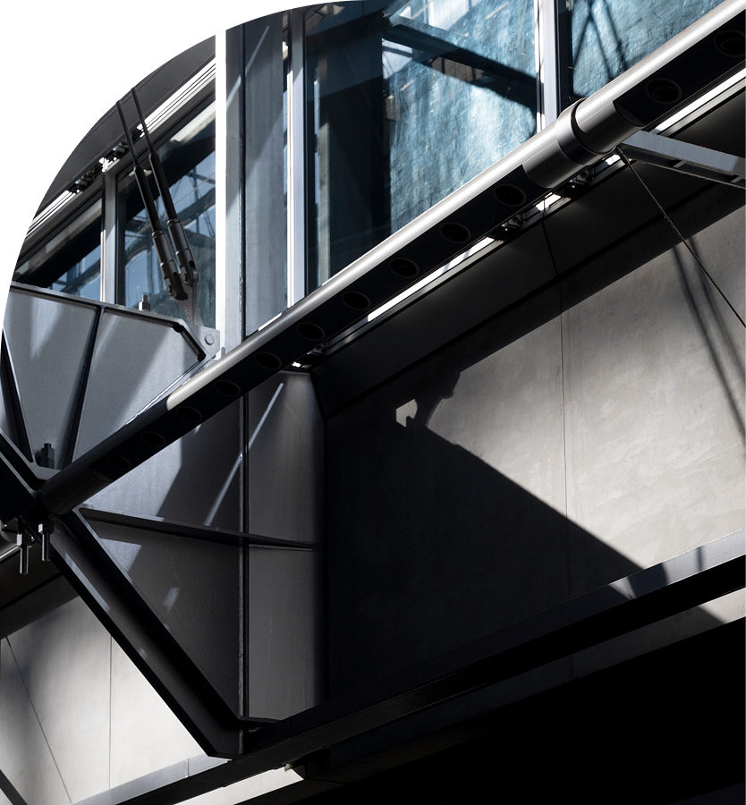 Close-up of modern metal and glass architectural structure with sharp shadows.