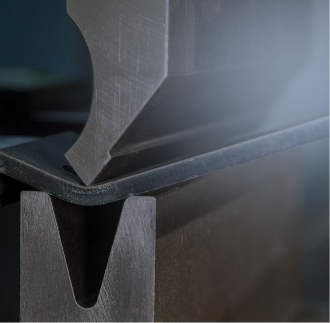 Close-up of a metal press brake bending a sheet of metal.