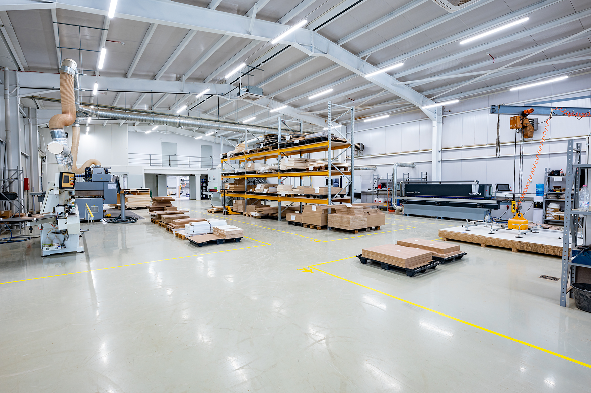 Large blue Euro currency symbol sculpture surrounded by yellow stars in front of modern glass skyscrapers under a blue sky.