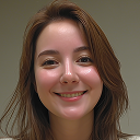 Smiling young woman with light skin and brown hair looking at the camera against a white background.