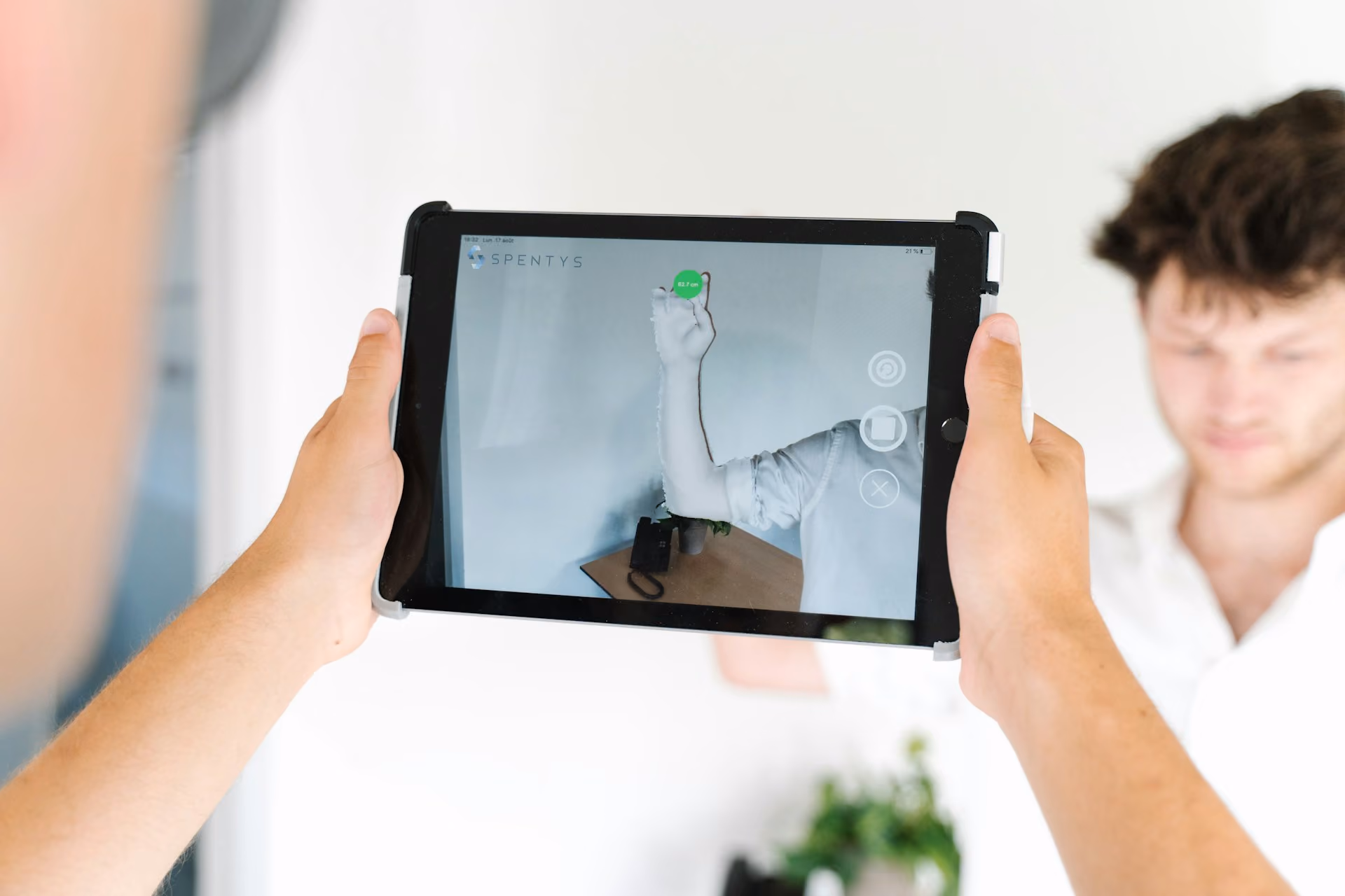 Hände halten ein Tablet und scannen einen Raum für die Datenaufnahme