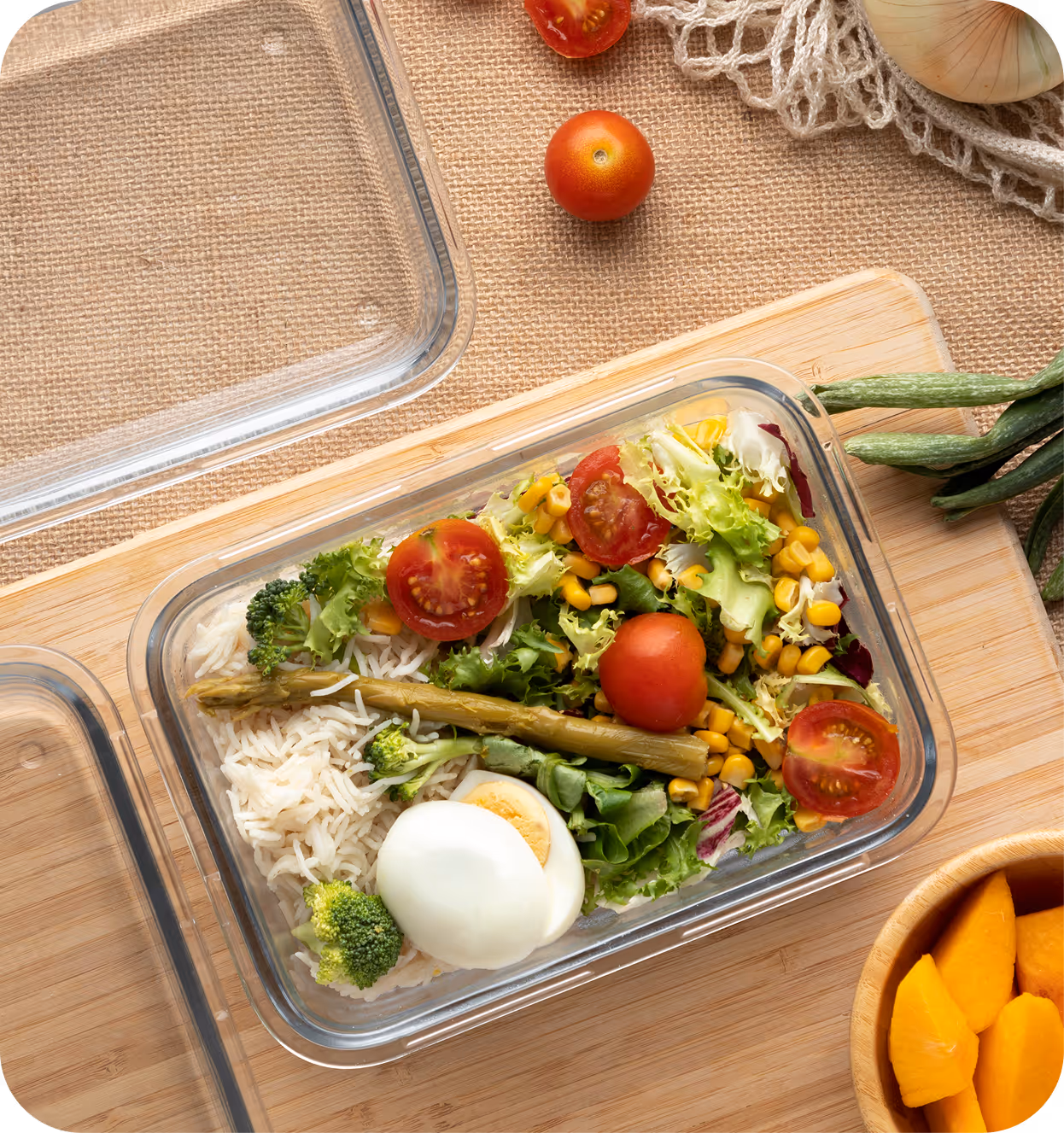 Boîte repas équilibrée avec légumes verts, asperges, tomates cerises et œuf dur, prête à emporter.