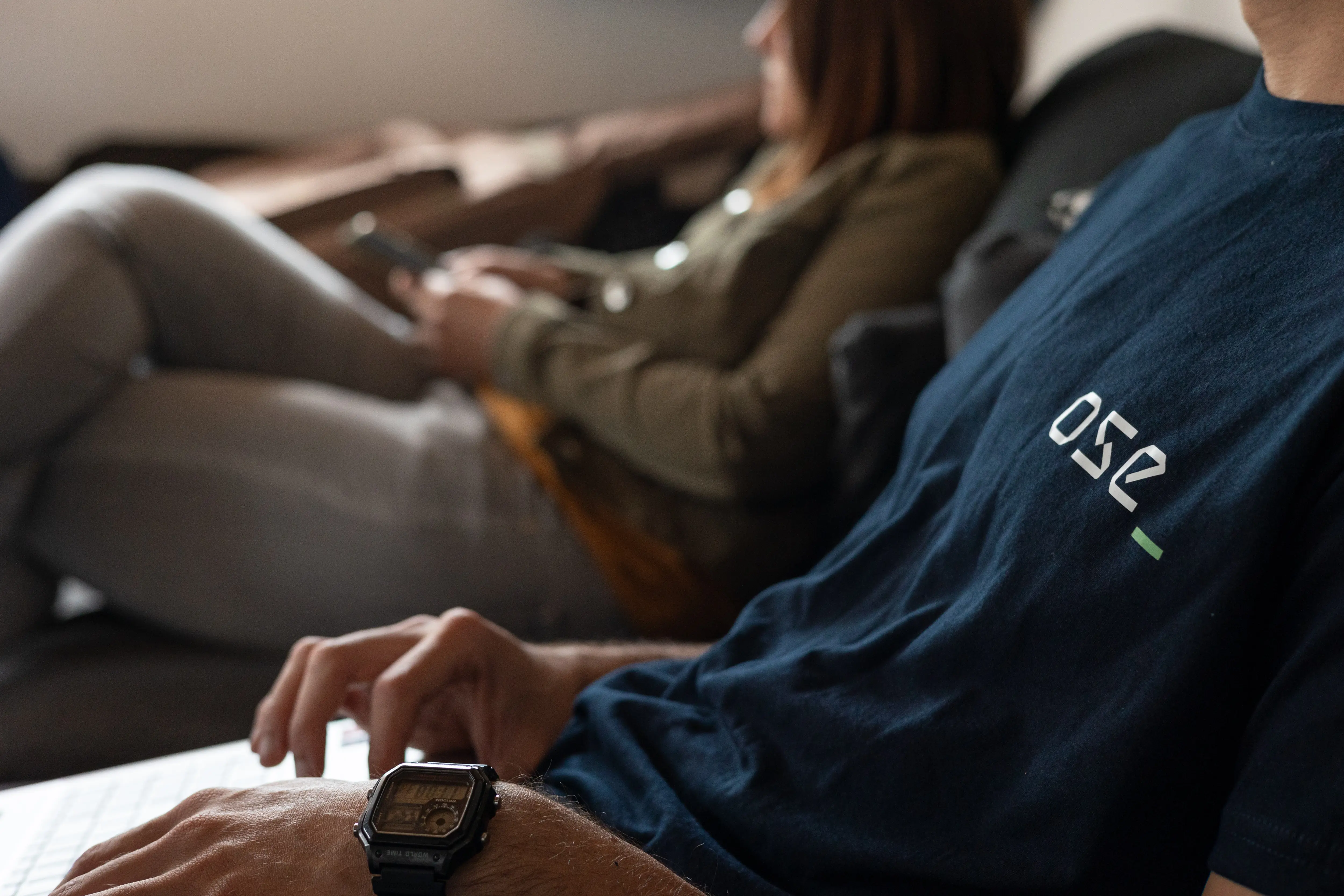 Groupe de personnes en tenue décontractée discutant lors d'un rassemblement en plein air avec des arbres en arrière-plan.