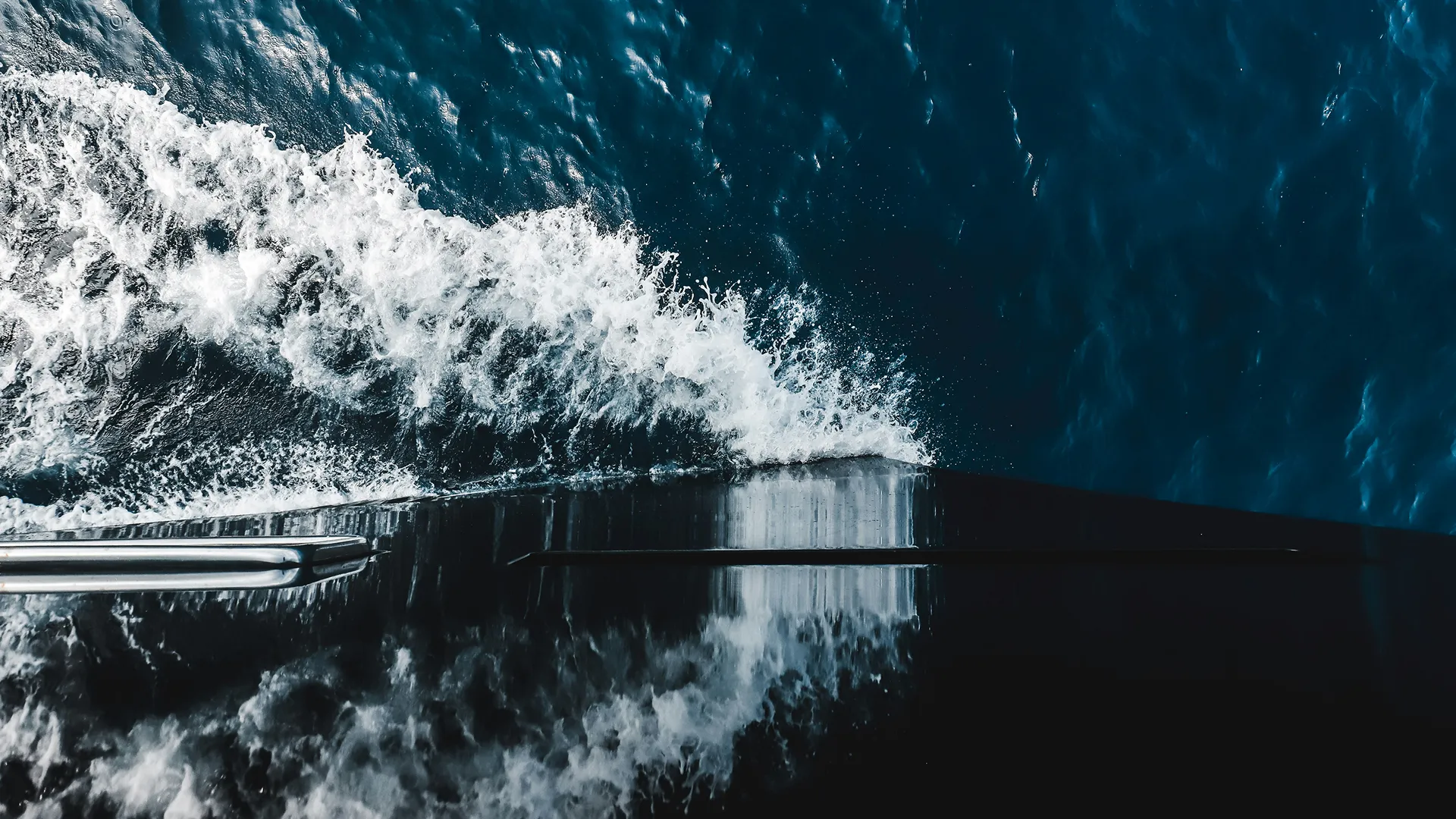 Vague blanche créée par la proue d'un bateau se déplaçant dans une mer bleue profonde.