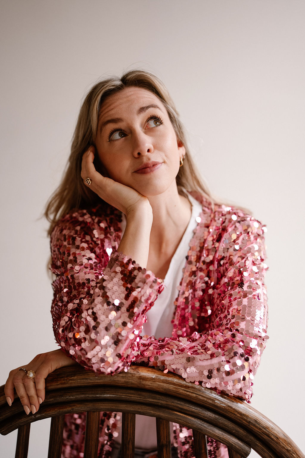Portret van Jasmijn in een roze paillettenjasje die glimlachend schuin naar bovenkijkt