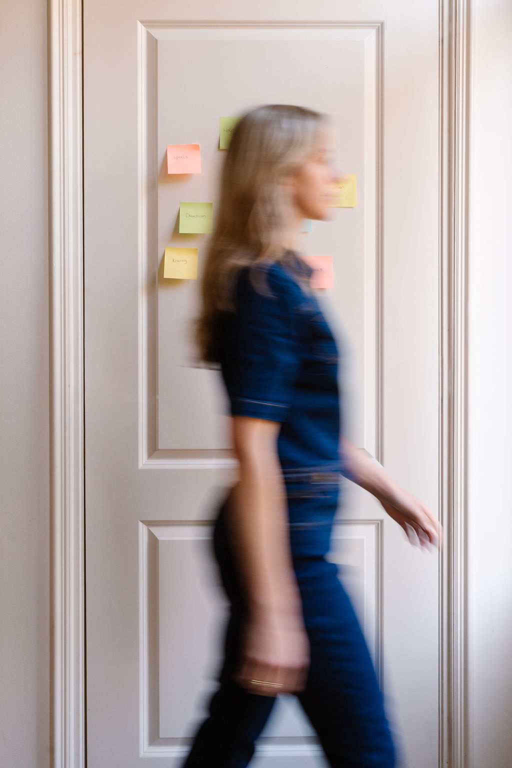 Foto waarin Jasmijn langs een muur loopt waaraan post its hangen