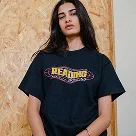 Woman with long dark hair wearing a black T-shirt with a colorful 'Remember' graphic on the front.