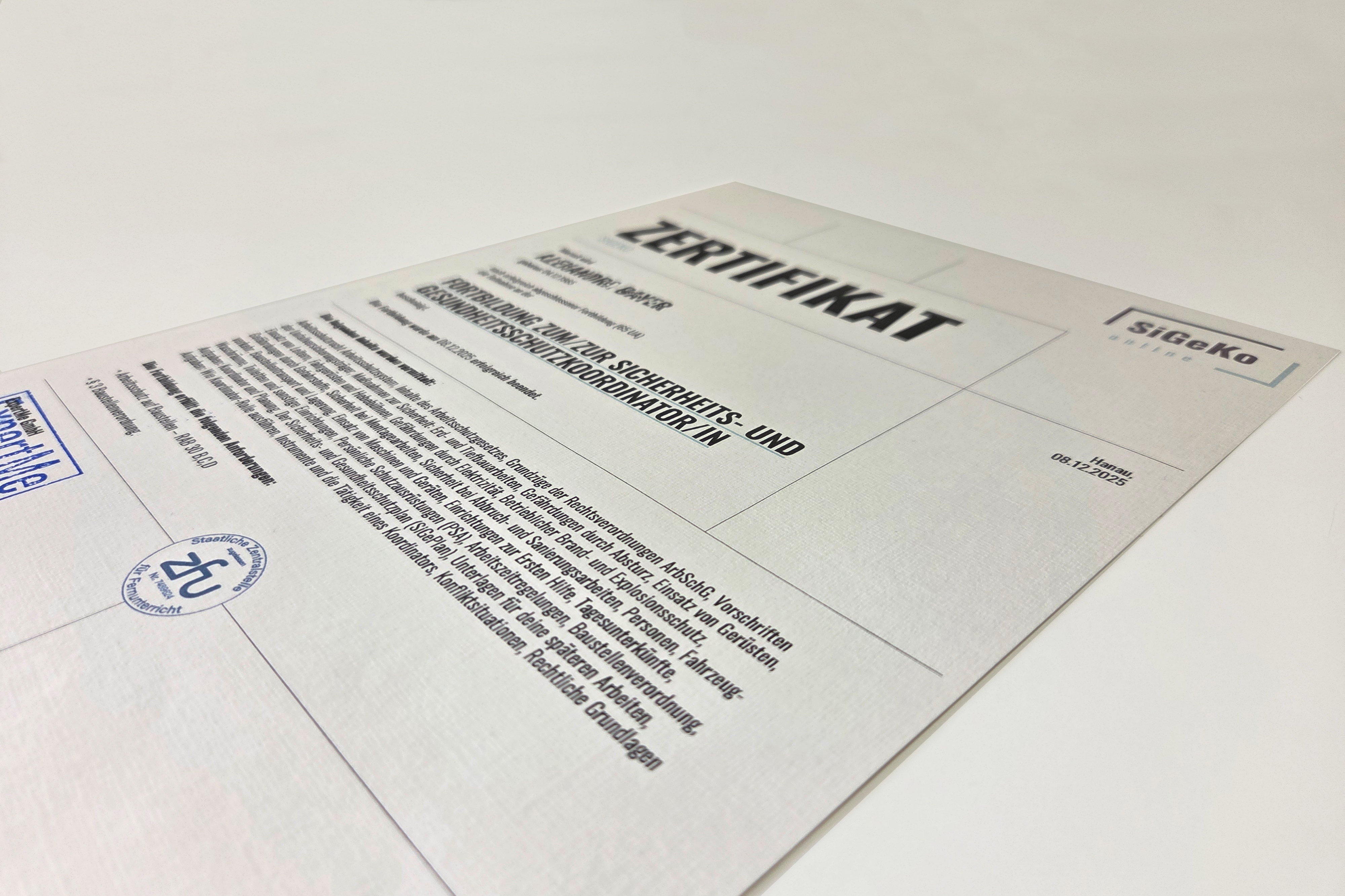 Fotografie eines SiGeKo-Zertifikats, das eine Schulung zum Sicherheits- und Gesundheitsschutzkoordinator bestätigt.