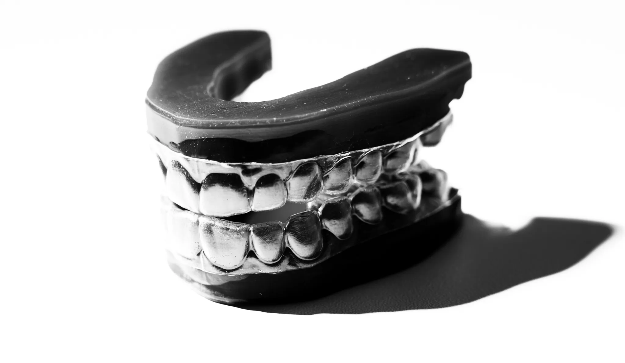 Black and white dental mold showing upper and lower teeth casting with detailed teeth impressions.