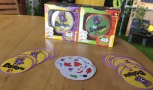 The board game Dobble on a table with colourful yellow and purple cards ready to play