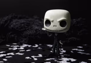 A plastic figure of Jack Skellington from the film The Nightmare Before Christmas, a skeleton wearing a pinstripe suit, on a black and white background