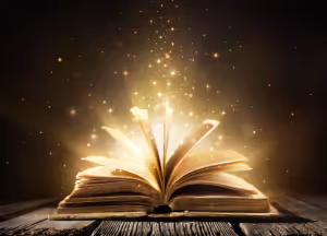 a story book lying open on its spine with golden light coming out of it
