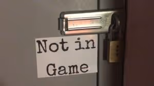 A sign reading NOT IN GAME by a door that is padlocked shut