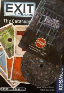 The escape room board game Exit, showing blue answer cards, orange riddle cards and green hint cards, as well as a code wheel and a folded poster